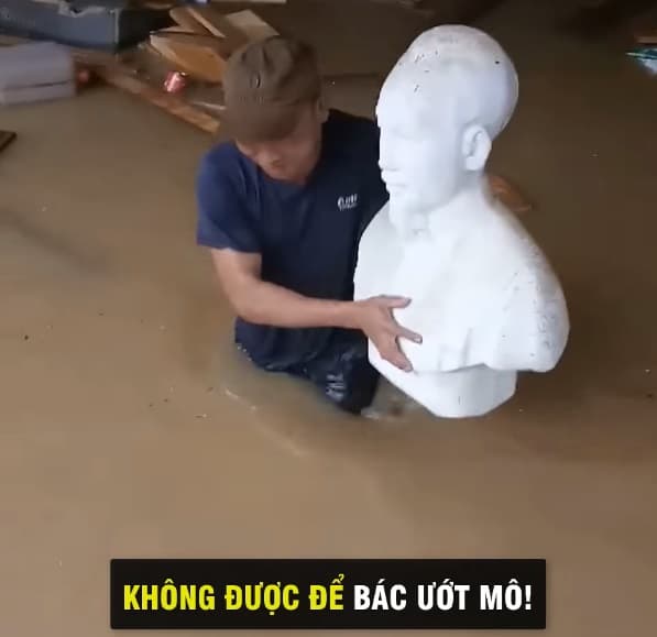 Khoảnh khắc xúc động người đàn ông che mũ cho tượng Bác trong mưa lũ 6
