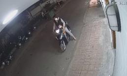 Người phụ nữ chở theo con nhỏ đứng canh chừng cho chồng bẻ khóa, trộm xe máy