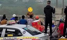 Cô gái trẻ đứng vắt vẻo trên thành cầu dọa nhảy khiến đám đông xúm lại khuyên can