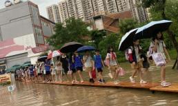 Hà Nội ngập sâu: Trường học kê bàn thành 'cầu' cho học sinh ra về không bị ướt