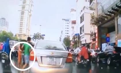Thanh niên đi 'xế hộp' tranh thủ hôi chùm vải của người bán hàng rong rơi trên đường